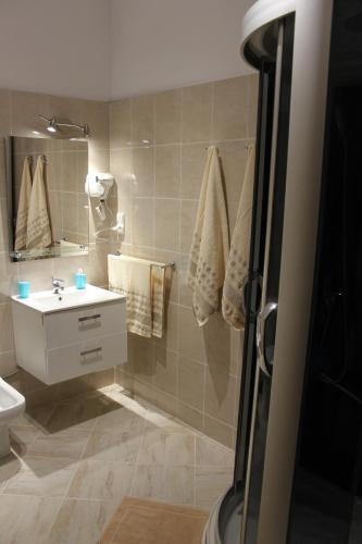 a bathroom with a sink and a toilet and a mirror at Apartamenty Vesuvio in Dźwirzyno