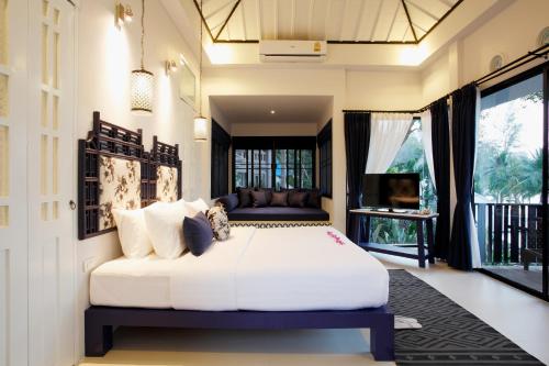 a bedroom with a large white bed in a room at Moracea by Khao Lak Resort in Khao Lak