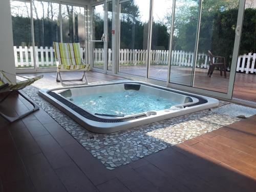 - un bain à remous sur une terrasse couverte avec une chaise dans l'établissement Le Relais de Voisins, à Voisins-le-Bretonneux