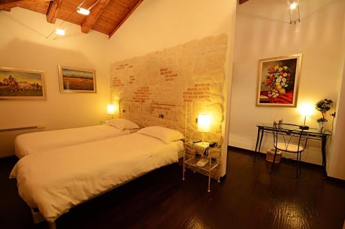 MonteveglioにあるLocanda Gli Uliviのベッドルーム1室(ベッド2台、テーブル2台、ランプ2つ付)