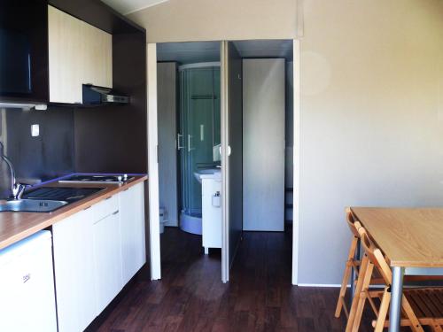 a kitchen with white cabinets and a wooden floor at Parque de Campismo Orbitur Vagueira in Gafanha da Boa Hora