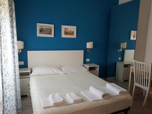 Un dormitorio azul con una cama con toallas. en La Dolce Vita Rome Ciampino en Ciampino