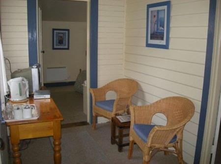 a room with two chairs and a table and a door at Ross B&B Accommodation in Ross