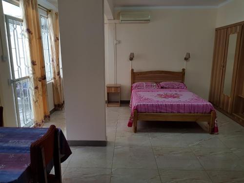 a bedroom with a bed with a purple comforter at Pereybere Beach Apartments in Pereybere