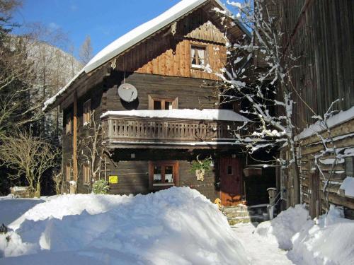 a log cabin with a pile of snow in front of it at Almliesl LUNG-495 in Annaberg im Lammertal