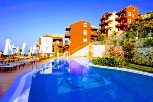 una piscina con mesas y edificios en el fondo en Ippoliti Village, en Hersonissos