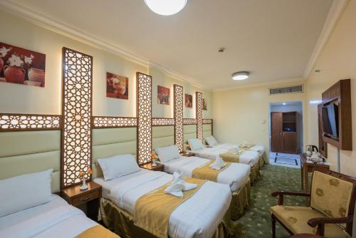 una fila de camas alineadas en una habitación en Rawdhat Al Mukhtara Hotel, en Medina