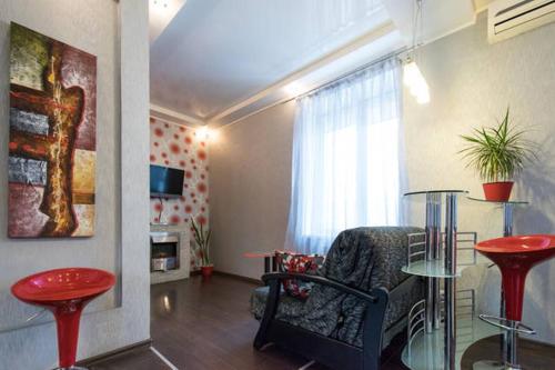 a living room with a chair and a glass table at Modern luxury studio in the center of Kharkiv at Konstitutsii Square in Kharkiv