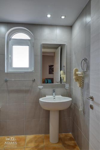 a bathroom with a sink and a mirror at Corinna Mare in Kalamaki Chanion