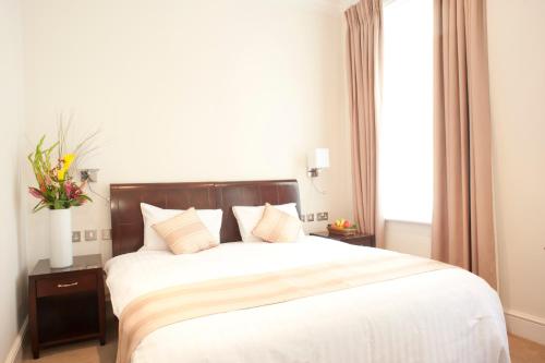 a bedroom with a large bed and a window at The Villa Kensington in London