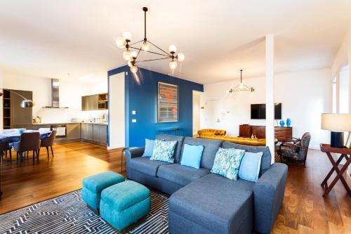 a living room with a blue couch and a dining room at Chalet Estoril Luxury Apartments in Estoril