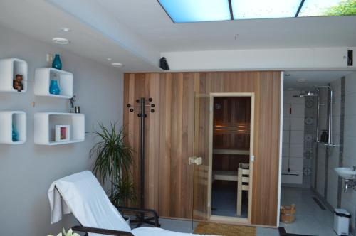 a bathroom with a shower with a wooden door at Fletcher Parkhotel Val Monte in Berg en Dal
