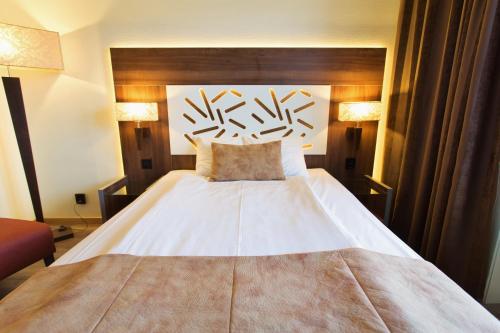 a bedroom with a large white bed with a wooden headboard at Hotell Östersund in Östersund