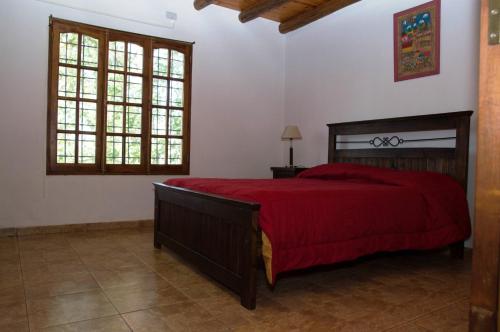 1 dormitorio con 1 cama grande de color rojo en una habitación en Familia Tejada en Mendoza