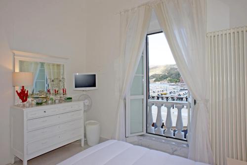 a white bedroom with a large window with a view at Vittoria in Lerici