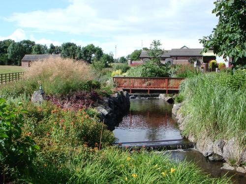 a red bridge over a river with a bridge at The Stables B&B in Antrim