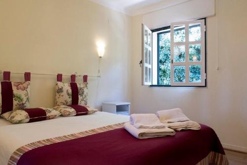a bedroom with a bed with towels on it at Casa do Castelo in Santiago do Cacém