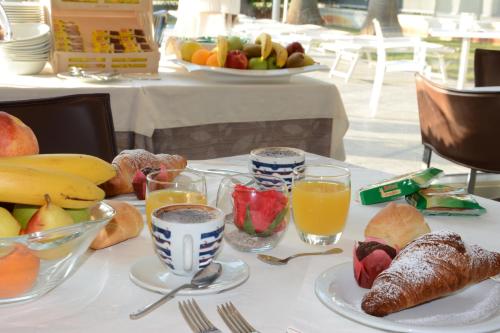 a table with a breakfast of fruit and juice at Kiara Residence in Giulianova