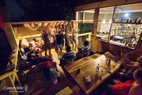 a group of people sitting in a room with a table at Bella's Backpackers Cayo in San Ignacio