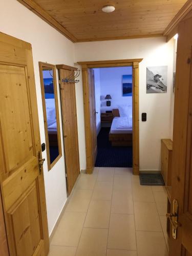 a hallway of a room with a bed and a door at Brenners Dorfstube in Fieberbrunn