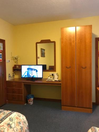 a bedroom with a desk with a computer and a mirror at The Stables B&B in Antrim
