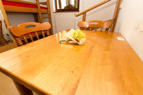 a wooden table with a yellow flower on it at Tourist Farm Pri Martinovih in Krška Vas