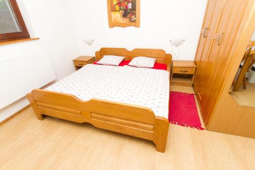 a bedroom with a wooden bed with two pillows at Tourist Farm Pri Martinovih in Krška Vas