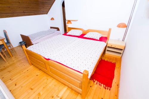a small bedroom with a bed and a wooden floor at Tourist Farm Pri Martinovih in Krška Vas