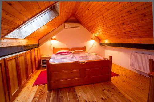 a bed in a room with a wooden ceiling at Tourist Farm Pri Martinovih in Krška Vas
