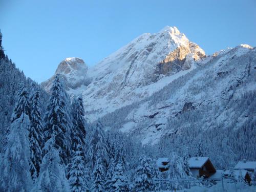 a snow covered mountain with a house in the foreground at Villa Adria B&B in Canazei