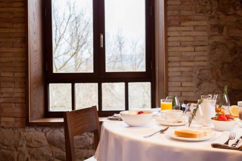 a table with a white table cloth and food on it at Fuente Aceña Hotel Boutique in Quintanilla de Onésimo