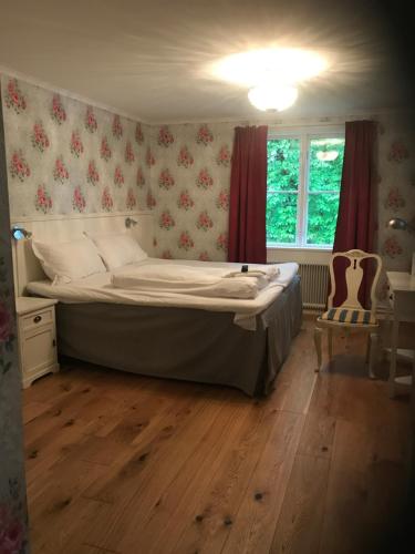 um quarto com uma cama e uma janela em Hellefors Herrgård em Hällefors