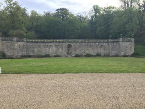 a large stone wall with a field of grass at La Grande Maison in Seine-Port