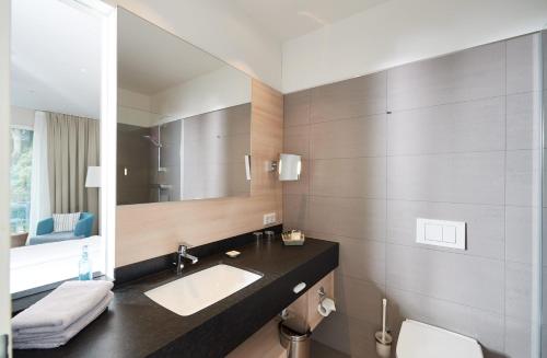 a bathroom with a sink and a mirror at Seehotel Kressbronn in Kressbronn am Bodensee