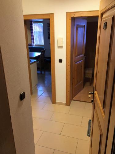 a hallway with a door and a room with a table at Brenners Dorfstube in Fieberbrunn