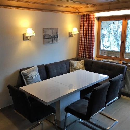 a living room with a table and a couch at Brenners Dorfstube in Fieberbrunn