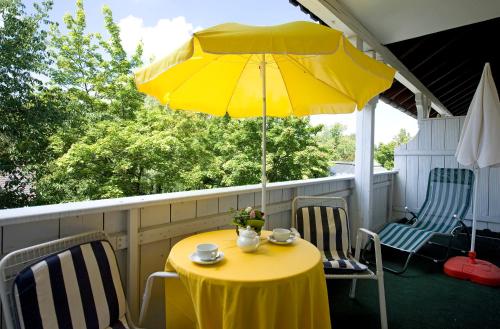 a yellow table and chairs under a yellow umbrella at Ferienwohnungen KUR-ECK in Bad Wörishofen