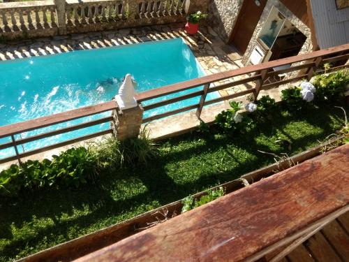 a swimming pool in a yard with a wooden fence at Chalé Pedroso Monte Verde in Monte Verde