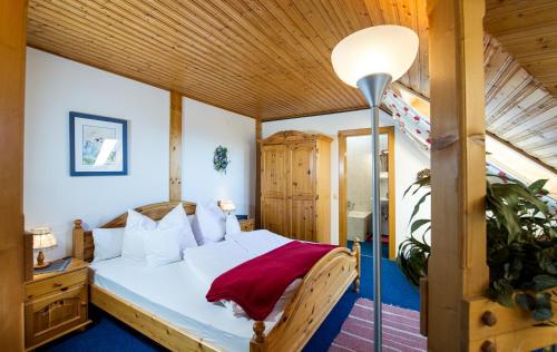 een slaapkamer met een bed en een lamp bij Ferienwohnungen Salmen in Pörtschach am Wörthersee