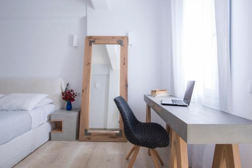 a bedroom with a desk with a laptop and a chair at Blue Waves Suites & Apartments in Kamari