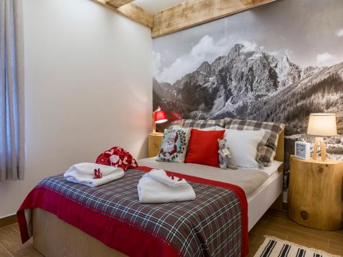 a bedroom with a bed with a mountain mural on the wall at Chaty Zakopane in Zakopane
