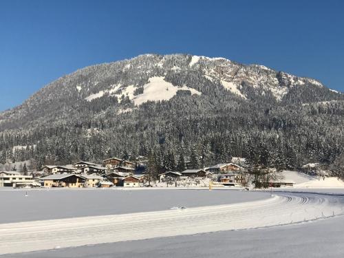 a snow covered mountain in front of a ski resort at Kössen DORF41 TOP2 in Kössen