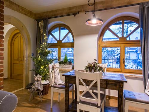 a dining room with a table and chairs and windows at Chaty Zakopane in Zakopane
