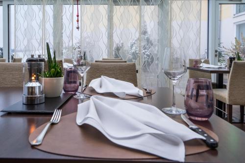 a table with a white napkin and fork and knife at Taste Hotel Heidenheim in Heidenheim