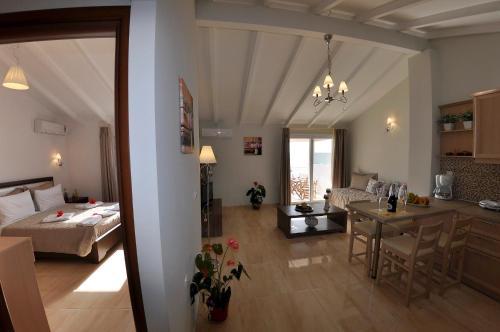 a bedroom and a living room with a bed and a table at Mazis Apartments in Agios Gordios