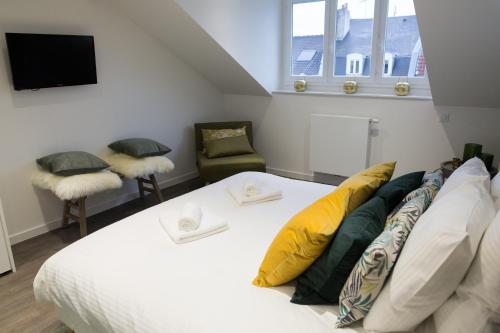 a bedroom with a bed and two chairs and a tv at Luxueux logement Bourgeois de 250 M2 climatisé in Lille