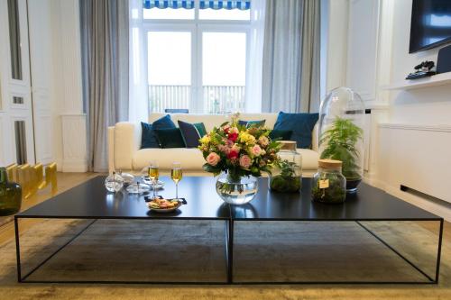 a living room with a coffee table with flowers on it at Luxueux logement Bourgeois de 250 M2 climatisé in Lille