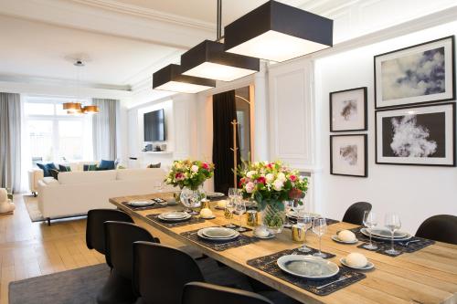 une salle à manger avec une grande table et des chaises dans l'établissement Luxueux logement Bourgeois de 250 M2 climatisé, à Lille