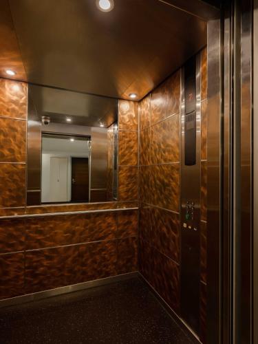 a bathroom with a mirror and a elevator at Silom Lofts in Bangkok