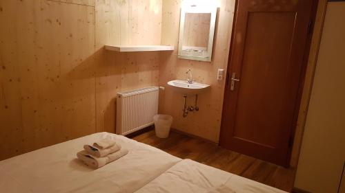 Zimmer mit einem Bett, einem Waschbecken und einem Spiegel in der Unterkunft Auerhahn in Feldberg